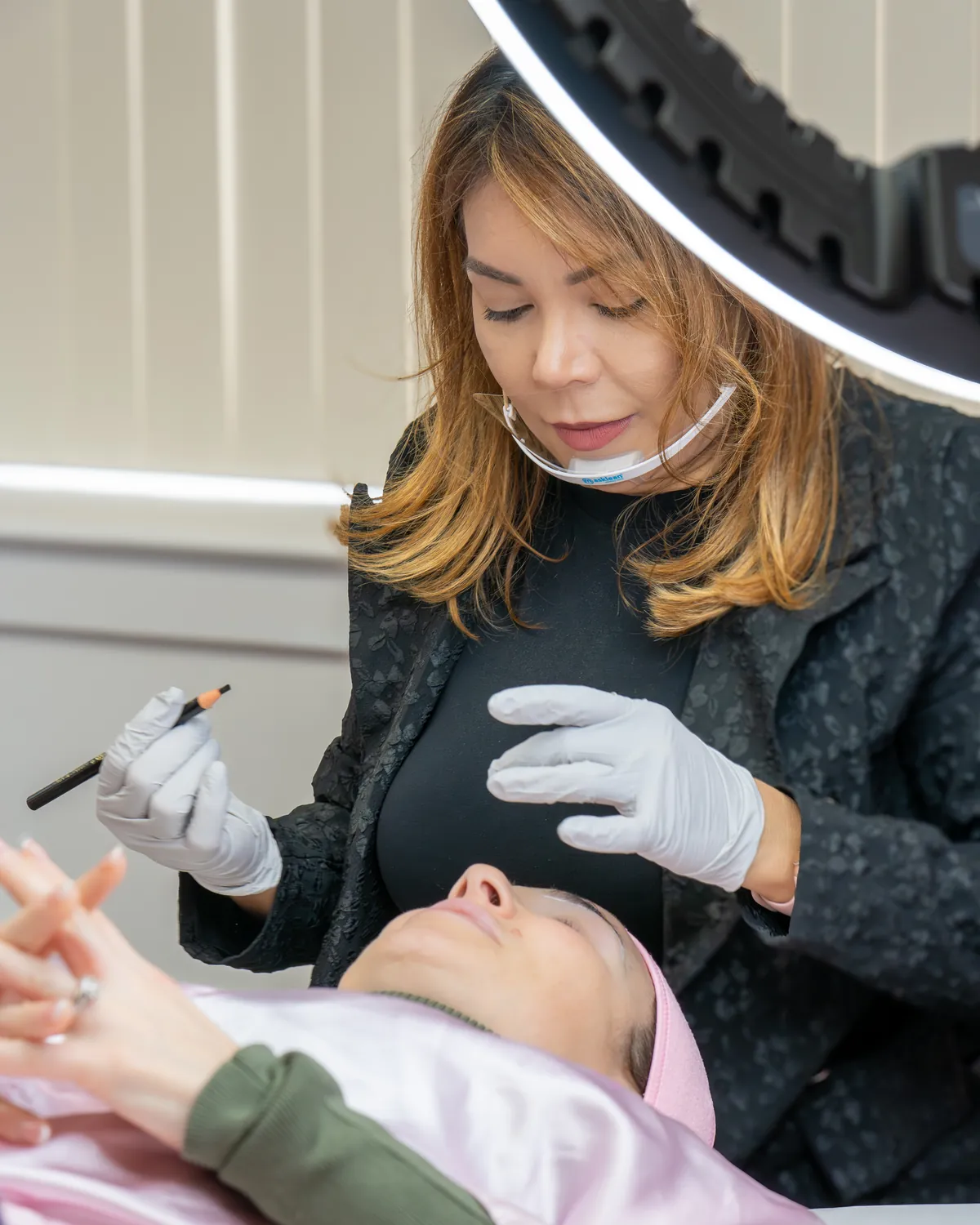Adriana Souza Santos guiding a hands-on permanent makeup session on a live model at Adriana's Academy in Peabody, MA