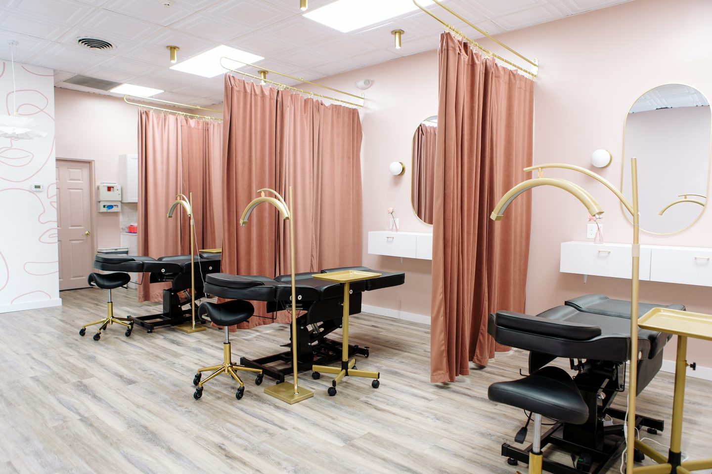 Treatment room at the Salem, NH studio with curtained private stations and adjustable procedure beds