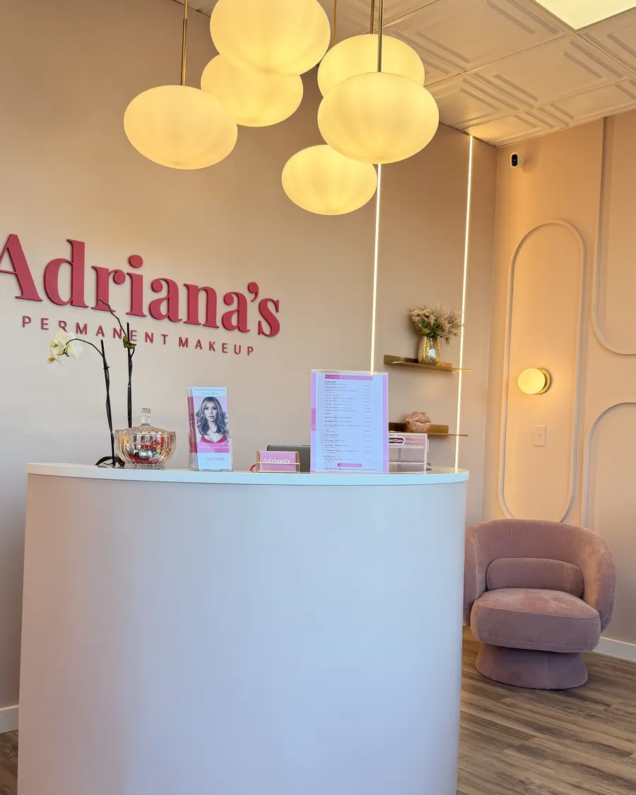 Reception of the Salem, NH studio with the Adriana's wall logo and globe pendant lights