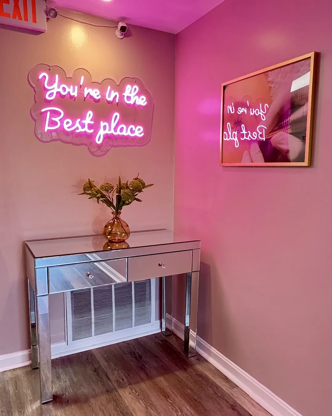 Neon sign reading You're in the Best place on the pink accent wall of the Wilmington, MA studio