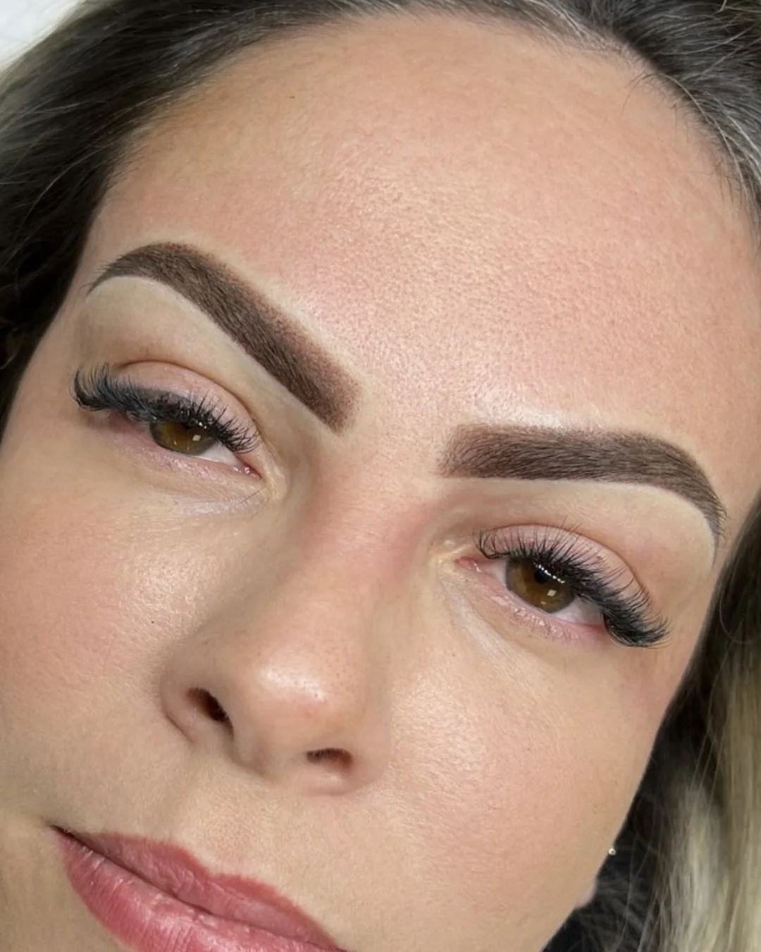 Healed powder brows with a soft shaded fill and a defined tail, no visible hair strokes